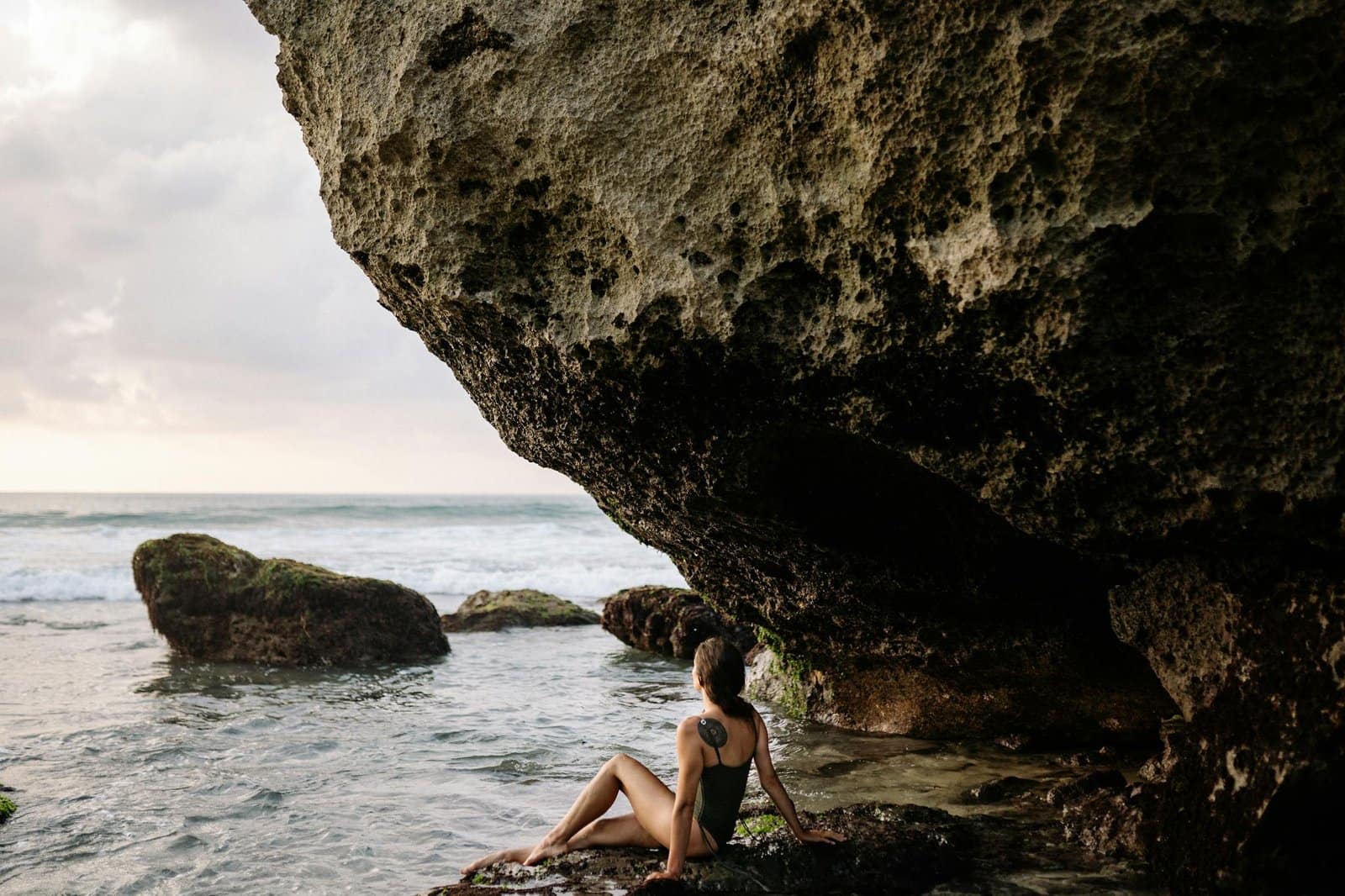 Young lady resting on rocky coast